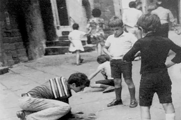 ragazzi che giocano in strada a tappetti - Viterbo anni '60, collezione Galeotti